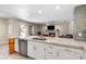 Open-concept kitchen and living room with island seating, stainless steel appliances and fireplace at 5449 Desert Spring Rd, Las Vegas, NV 89149