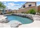 Backyard pool with rock features, seating area and blue umbrella at 5449 Desert Spring Rd, Las Vegas, NV 89149