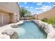 Sparkling pool with natural rock accents and serene backyard landscaping at 5449 Desert Spring Rd, Las Vegas, NV 89149