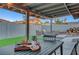 Close-up of outdoor dining area with table setting, plant, and view of lounge area with fire pit at 58 Pleasant Dale Dr, Henderson, NV 89074