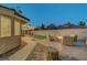 Cozy backyard seating area with fire pit and an extended, well-lit covered patio at 58 Pleasant Dale Dr, Henderson, NV 89074