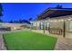 Serene backyard featuring artificial turf, a seating area with fire pit, and covered patio for outdoor dining at 58 Pleasant Dale Dr, Henderson, NV 89074