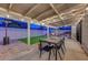 Backyard featuring a covered patio, outdoor dining, a fire pit, and synthetic grass at 58 Pleasant Dale Dr, Henderson, NV 89074