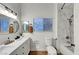 Bright bathroom featuring dual sinks, modern fixtures, and a tiled shower at 58 Pleasant Dale Dr, Henderson, NV 89074
