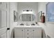 Bright bathroom featuring double sinks, sleek black fixtures, and modern oval mirror at 58 Pleasant Dale Dr, Henderson, NV 89074