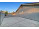 Side view of the home showing textured stucco exterior, access to the backyard, and concrete driveway at 58 Pleasant Dale Dr, Henderson, NV 89074