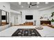 Bright living room with a modern fireplace, ceiling fan, and adjacent open kitchen at 58 Pleasant Dale Dr, Henderson, NV 89074