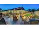 Inviting outdoor patio with wicker furniture, stylish pavers, a modern fire pit, and ambient string lights at 58 Pleasant Dale Dr, Henderson, NV 89074