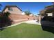 The backyard has artifical turf, a terraced block wall, patio, and covered area at 6002 Stone Hollow Ave, Las Vegas, NV 89156