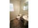 Stylish half-bathroom featuring a pedestal sink, wood-look flooring, and modern fixtures at 6002 Stone Hollow Ave, Las Vegas, NV 89156