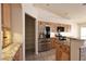 Modern kitchen with wooden cabinetry, stainless steel appliances, granite countertops and custom tile floors at 6016 Bungalow Bay St, Las Vegas, NV 89130