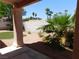 Inviting backyard with covered patio, rock landscaping, palm trees and a brick privacy wall at 613 Cervantes Dr, Henderson, NV 89014