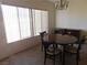 Cozy dining room featuring a wooden table, four chairs, and bright natural light from large windows at 613 Cervantes Dr, Henderson, NV 89014