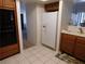 Functional kitchen with white refrigerator, black oven, tiled floors and wood cabinets at 613 Cervantes Dr, Henderson, NV 89014