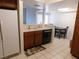 Practical kitchen with white refrigerator, wooden cabinets, and view into dining area at 613 Cervantes Dr, Henderson, NV 89014