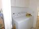 Bright laundry room features a white washer and dryer with white cabinets above for storage solutions at 613 Cervantes Dr, Henderson, NV 89014
