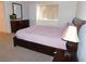 Sunlit main bedroom with a dark wood bed frame and dresser at 613 Cervantes Dr, Henderson, NV 89014