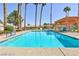 Beautiful community pool surrounded by lush landscaping and palm trees at 613 Cervantes Dr, Henderson, NV 89014