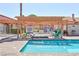 Community pool with shaded seating area surrounded by palm trees and landscaping at 613 Cervantes Dr, Henderson, NV 89014