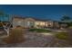 Charming backyard featuring lush green lawn, garden area, brick pathway and home exterior at twilight at 6333 Orto Vaso Ave, Las Vegas, NV 89131