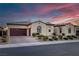Beautiful single-story home with a tile roof, arched windows, brick-paved driveway, manicured landscaping, and a two-car garage at 6333 Orto Vaso Ave, Las Vegas, NV 89131