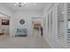 Spacious hallway with neutral tile flooring, plantation shutters, a view of the dining room, and a decorative mirror at 6333 Orto Vaso Ave, Las Vegas, NV 89131