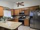 Bright kitchen with stainless steel appliances, wood cabinets, granite countertops, and tile flooring at 6361 Copperfield Ave, Las Vegas, NV 89108
