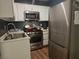 Galley kitchen features stainless steel appliances and white cabinetry at 6361 Copperfield Ave, Las Vegas, NV 89108