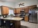 Well-lit kitchen with stainless steel appliances, granite countertops, wood cabinets and tile flooring at 6361 Copperfield Ave, Las Vegas, NV 89108