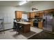 Bright kitchen featuring wood cabinets, stainless steel appliances, island with seating, and tile flooring at 6361 Copperfield Ave, Las Vegas, NV 89108