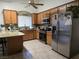 Well-lit kitchen with stainless steel appliances, wood cabinets, and granite countertops at 6361 Copperfield Ave, Las Vegas, NV 89108