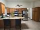 Spacious kitchen with oak cabinets, stainless steel appliances, and a granite countertop island at 6361 Copperfield Ave, Las Vegas, NV 89108