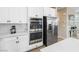 Gourmet kitchen with built-in stainless steel double ovens, modern white cabinets, and quartz countertops at 6611 Dove Point Pl, Las Vegas, NV 89130