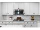 Close-up of a modern kitchen with quartz countertops, stainless steel microwave, and white subway tile backsplash at 6611 Dove Point Pl, Las Vegas, NV 89130