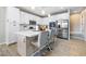 Modern kitchen with a center island, stainless steel appliances, white cabinetry, and breakfast bar seating at 6611 Dove Point Pl, Las Vegas, NV 89130