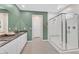Modern bathroom with double sinks, white cabinetry, quartz countertops, and glass-enclosed shower at 6834 Fallen Rock St, North Las Vegas, NV 89084