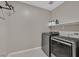 A laundry room featuring a new washer and dryer set, shelving, and a hanging rack at 6834 Fallen Rock St, North Las Vegas, NV 89084