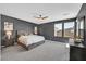 Spacious main bedroom featuring large windows, gray walls, and a ceiling fan at 6834 Fallen Rock St, North Las Vegas, NV 89084