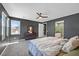 Bright main bedroom featuring a ceiling fan, gray walls and carpet, with an ensuite bathroom at 6834 Fallen Rock St, North Las Vegas, NV 89084