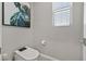 A view of a toilet room featuring a modern toilet and an interesting picture of a cow above the toilet at 6834 Fallen Rock St, North Las Vegas, NV 89084