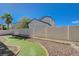 Expansive backyard featuring faux grass, rock landscaping, and full fencing for privacy at 6844 Tropicaire St, Las Vegas, NV 89149