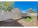 Fenced backyard with faux grass, rock landscaping, and space for entertaining or play at 6844 Tropicaire St, Las Vegas, NV 89149