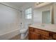 Well-lit bathroom featuring wood vanity, single sink, and shower-tub combo at 6844 Tropicaire St, Las Vegas, NV 89149