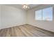 Bright bedroom features wood-look flooring, a ceiling fan, and a window with blinds at 6844 Tropicaire St, Las Vegas, NV 89149