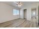 Bright bedroom features wood-look flooring, a ceiling fan, and a closet with sliding doors at 6844 Tropicaire St, Las Vegas, NV 89149