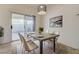 Staged dining room with a modern table and chairs and sliding glass doors to the patio at 6844 Tropicaire St, Las Vegas, NV 89149