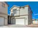 A two-story home featuring an attached two-car garage, complemented by beige siding and crisp, white trim at 6844 Tropicaire St, Las Vegas, NV 89149