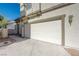 Attached two-car garage featuring a driveway, traditional carriage door, and an exterior sconce at 6844 Tropicaire St, Las Vegas, NV 89149