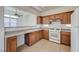 Well-lit kitchen offers wooden cabinetry, white appliances, and a cozy breakfast bar at 6844 Tropicaire St, Las Vegas, NV 89149
