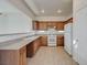 Traditional kitchen with wooden cabinets, neutral countertops and white appliances at 6844 Tropicaire St, Las Vegas, NV 89149
